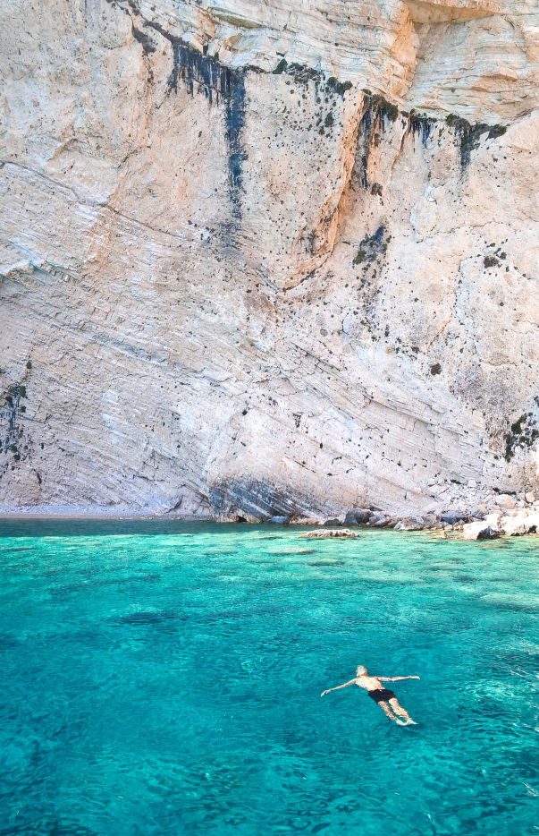human relaxing swimming in beautiful sea with rocks